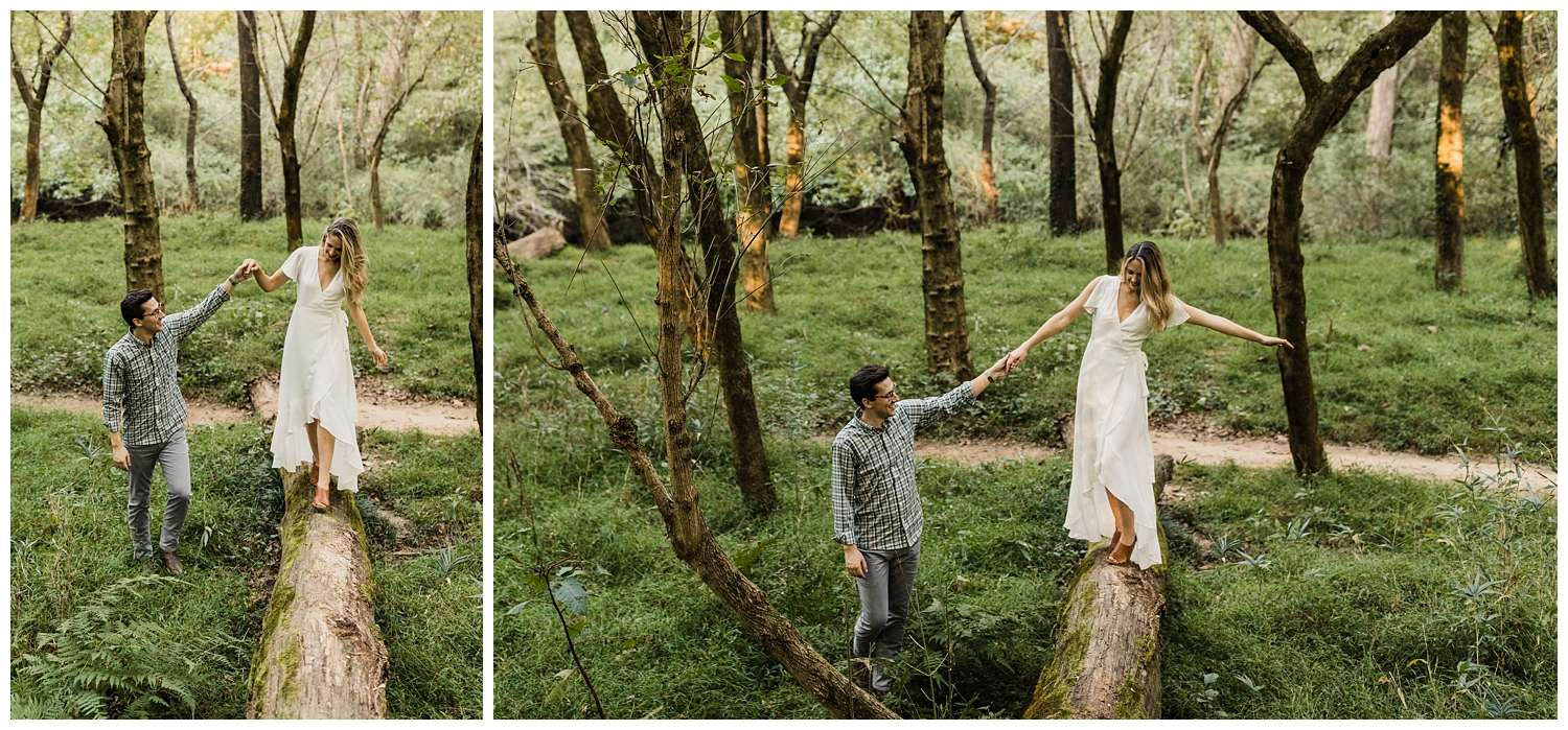 couple walking on a log during an engagement session in a lush, green forest in Atlanta, GA