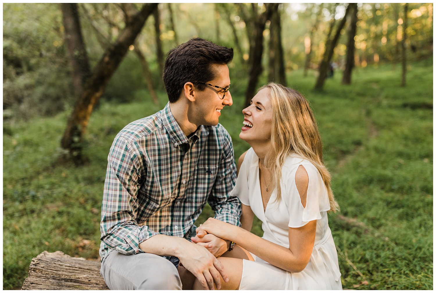 Engagement session in Atlanta, Georgia's Lullwater Park with couple laughing together in a lush, green forest