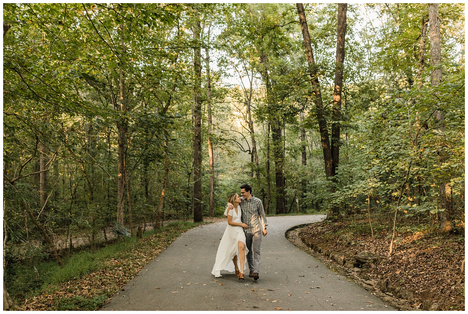 Young, engaged couple walking together on a trail in a forest in Atlanta, Georgia