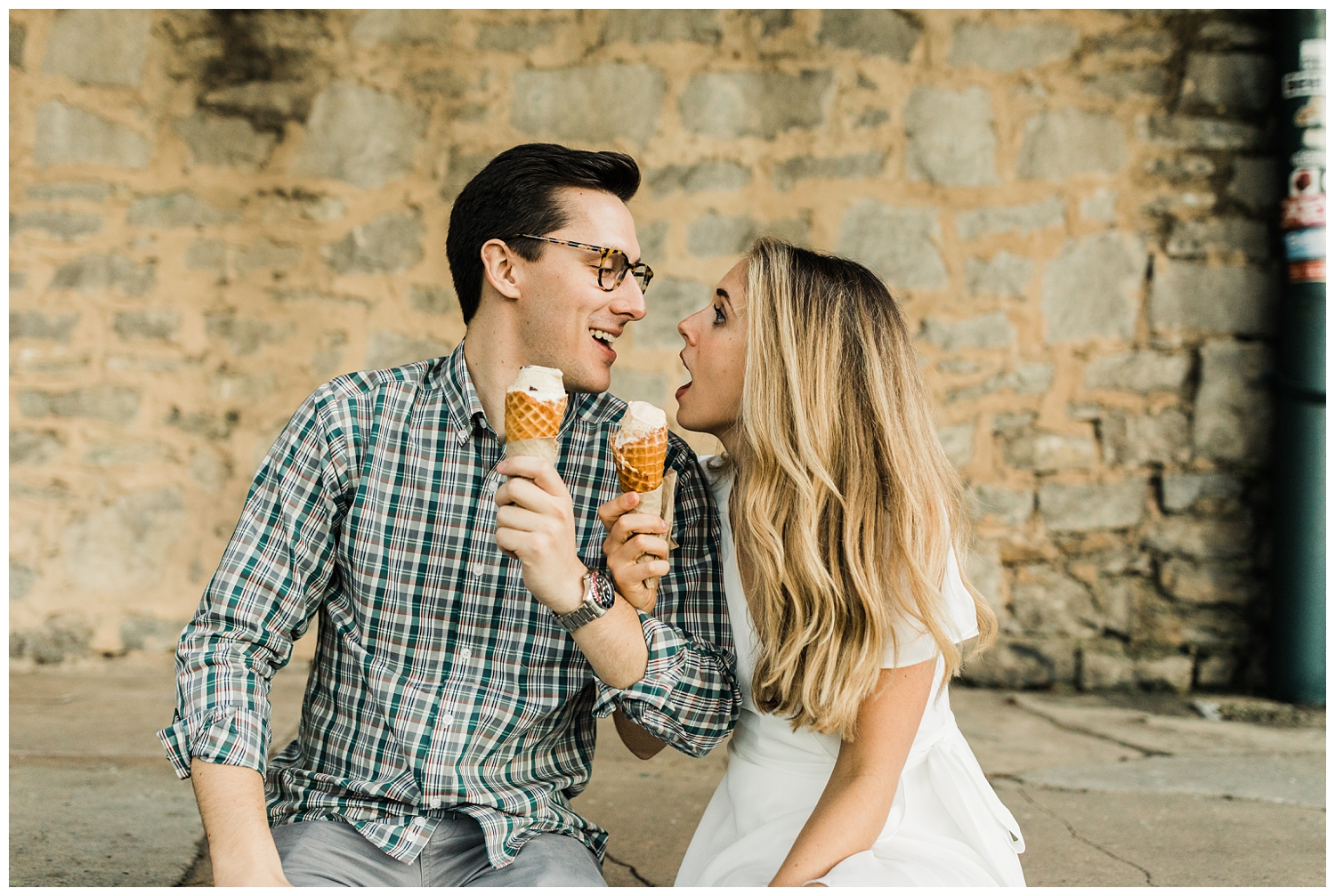 engagement session with brown-haired man and blonde girl in a white dress are eating ice cream and laughing together on the Atlanta Beltline