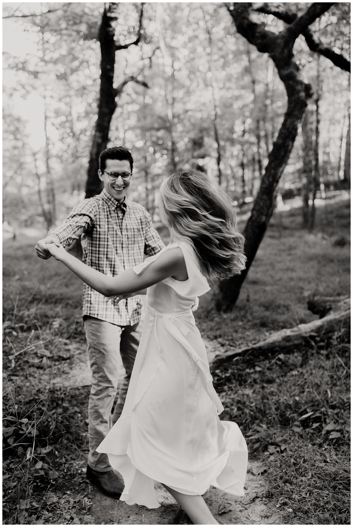 Newly engaged couple in Lullwater Park dancing during an engagement session in a lush, green forest in Atlanta, GA