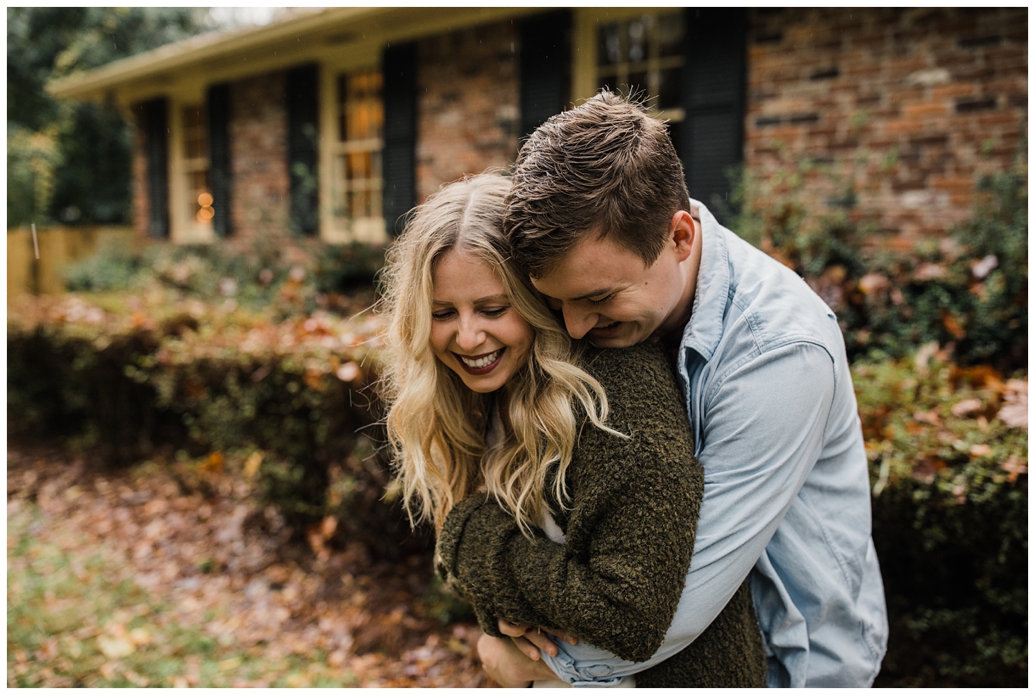 Rainy Day Engagement Session in Marietta, Georgia with cute couple laughing in the rain outside their brick home