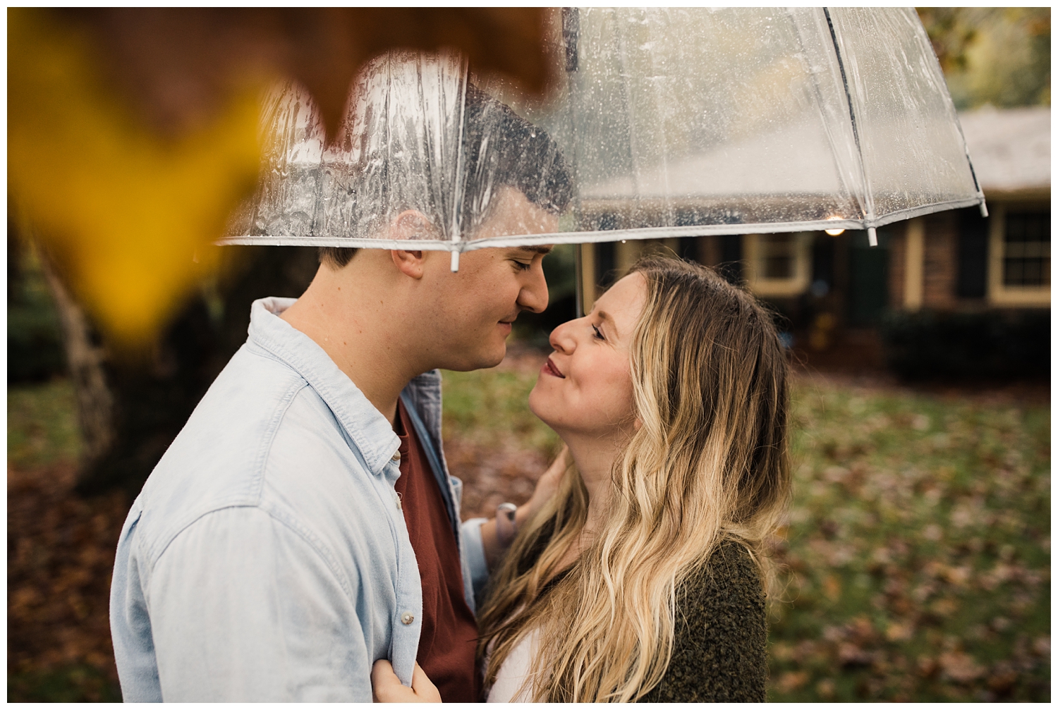 Rainy Day Engagement Session in Marietta, Georgia with cute couple standing under a clear umbrella in their front yard