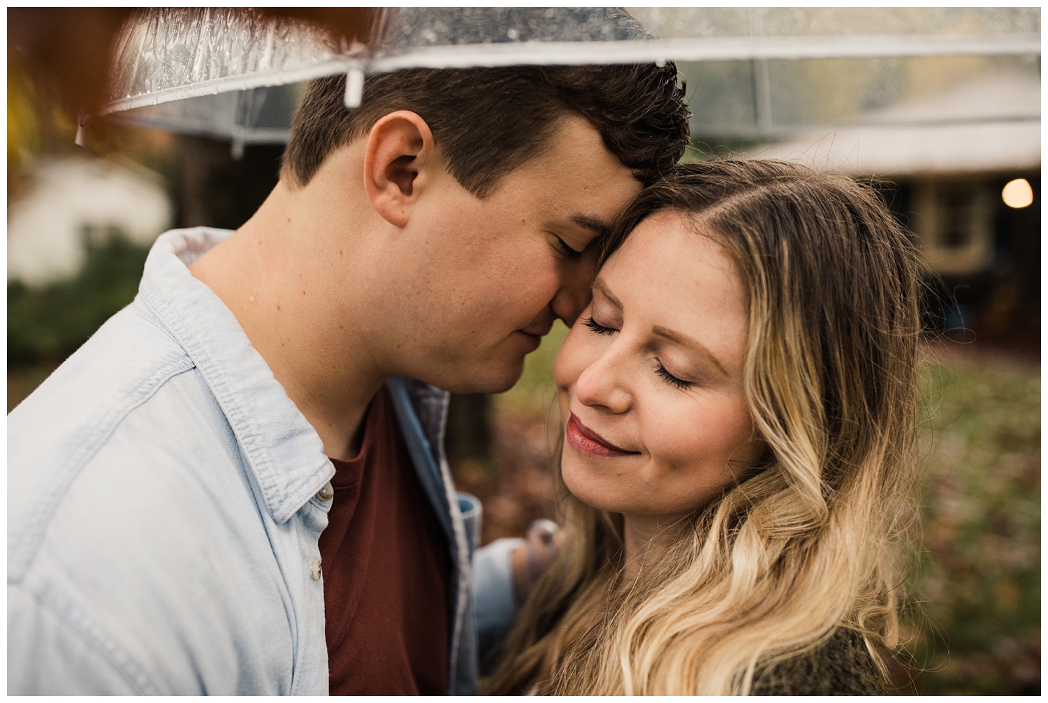Rainy Day Engagement Session in Marietta, Georgia with cute couple standing under a clear umbrella in their front yard