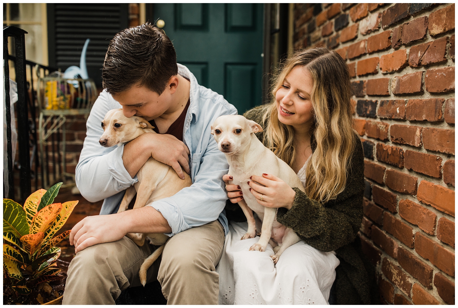 Rainy Day Engagement Session in Marietta, Georgia with cute couple sitting on their front porch with their two rescue dogs