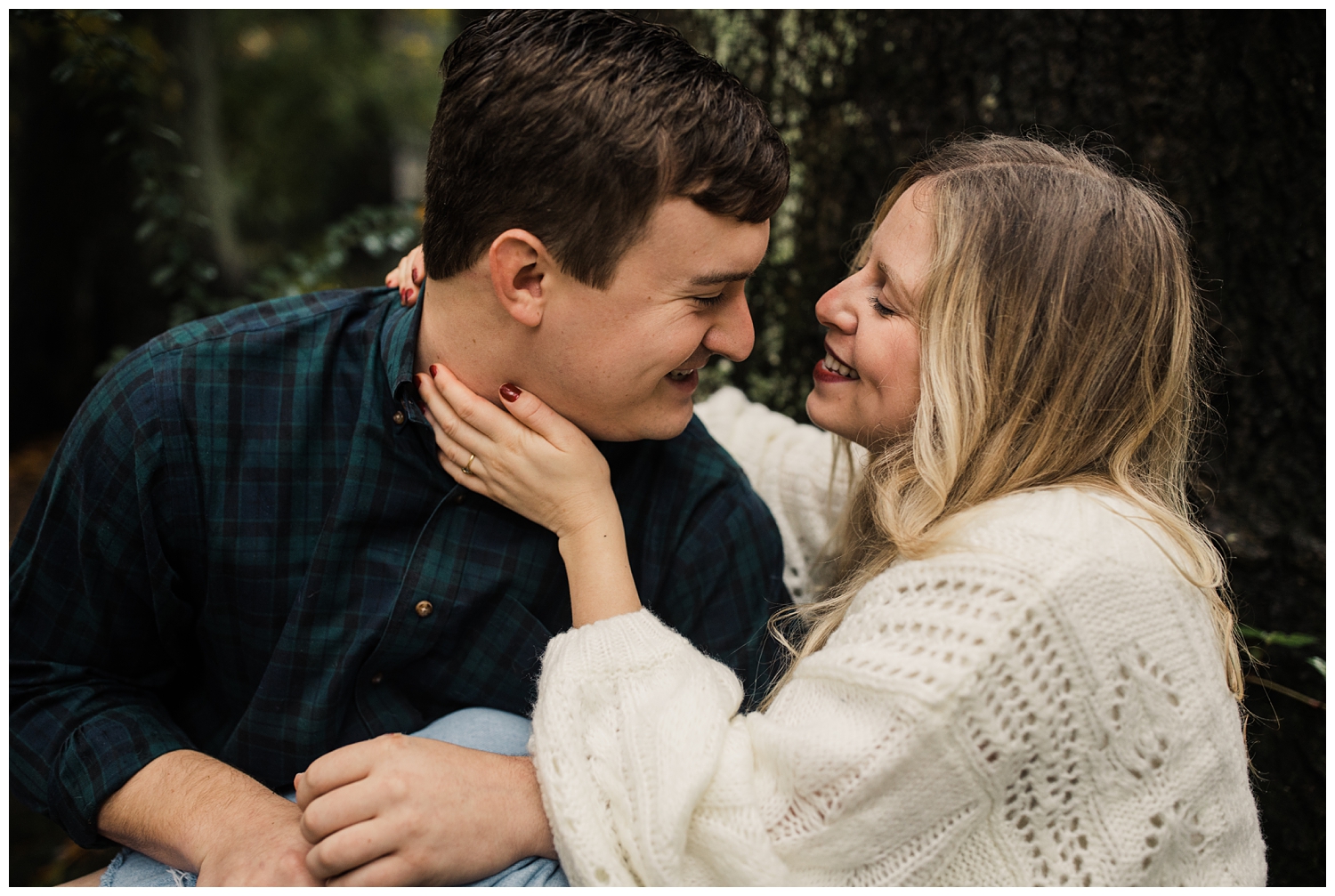 rainy day engagement session in marietta, georgia with cute couple sitting and laughing under a tree