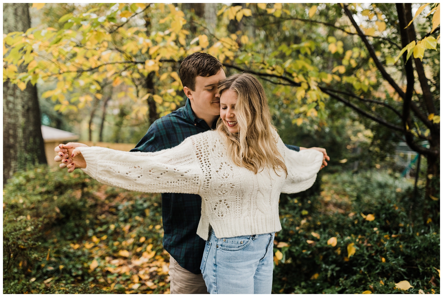 rainy day engagement session in marietta, georgia with cute couple walking and playing under a colorful yellow tree