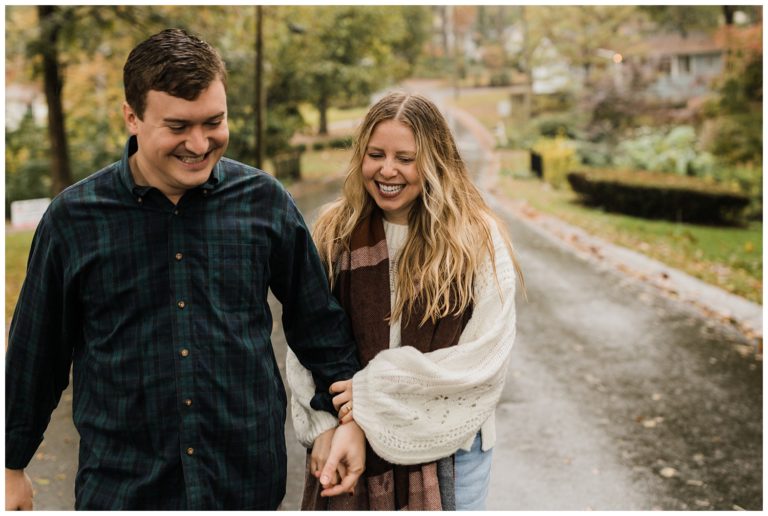 rainy day engagement session in marietta, georgia with cute couple running and laughing down a neighborhood street